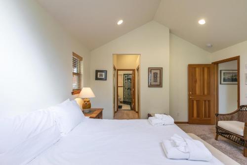 a bedroom with a large white bed and a chair at Silver Rock Lodge home in Zephyr Cove
