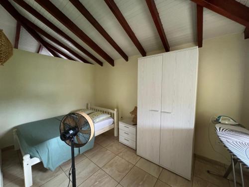 a bedroom with a bed and a fan in a room at Colibri studio in Les Abymes