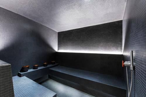 a bathroom with black walls and a bench with toilets at White 1921 Courchevel in Courchevel