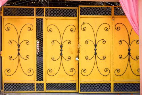 a group of yellow doors with scrolls on them at Hotel O Jannat in Chupra