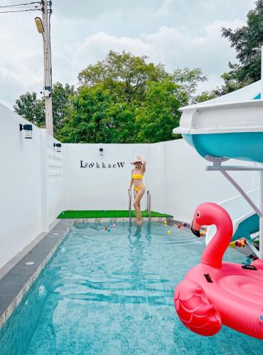 a woman in a swimming pool with a swan at บ้านพักเขาใหญ่ ลูกแก้วพูลวิลล่า Lookkaew Pool Villa Khaoyai in Ban Rai Khlong Sai