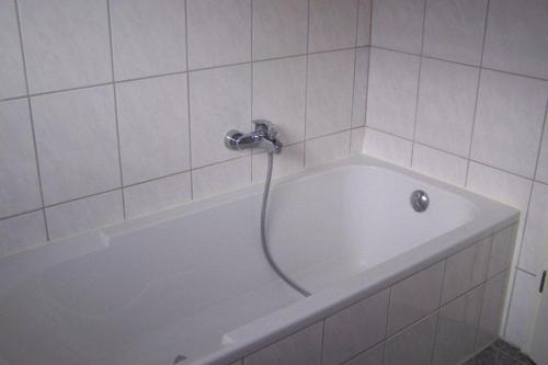 a white bath tub with a faucet in a bathroom at Carodorfblick in Carolinensiel
