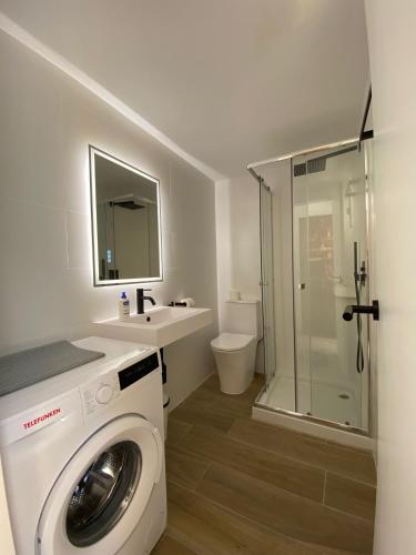 a bathroom with a washing machine and a sink at Formentera Suite 10 in Es Pujols