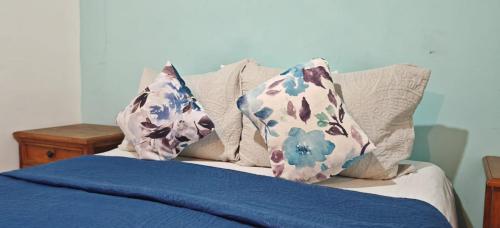 a bed with blue sheets and pillows on it at CASARU HOTEL OAXACA in Oaxaca City