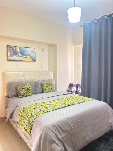 a bedroom with a large bed with a blue curtain at Nana Suites 1-bedroom with Swimming pool & Fast WiFi & Mall in Nairobi