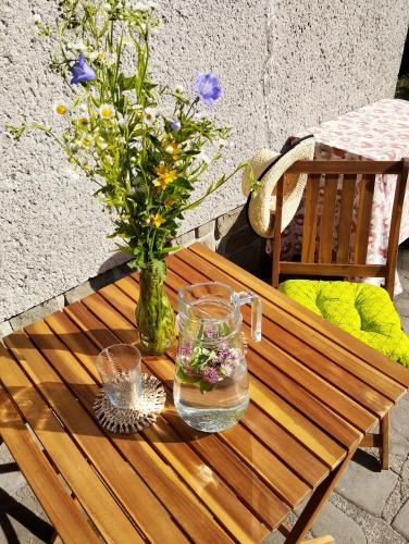 a wooden table with a vase of flowers on it at Domeček pod skokanskými můstky in Frenštát pod Radhoštěm