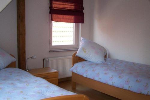 a small bedroom with two beds and a window at Carodorfblick in Carolinensiel