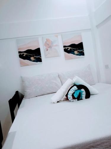 a bedroom with a white bed with pictures on the wall at 203 Casa de Rany in Daro