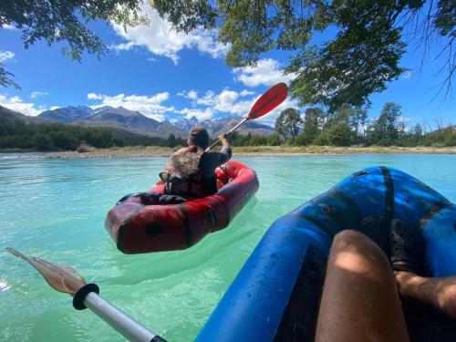 a man in a raft in the water with a paddle at Monte del Tigre Adventure Lodge in Cholila