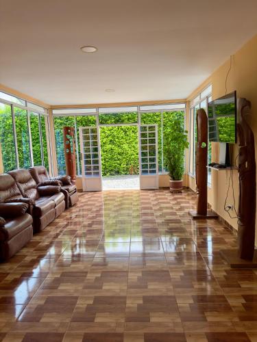a living room with a couch and a flat screen tv at Hotel Campestre Villa Alicia in Estación El Salto