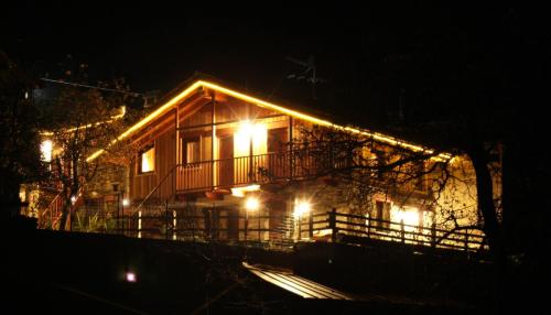 a house lit up at night with lights at Eco Chalet Maison Dominique in Challand Saint Anselme
