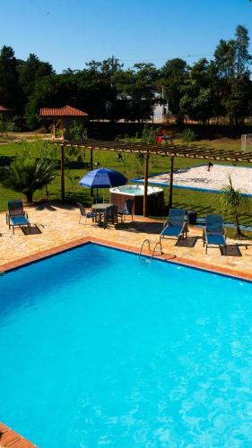 a swimming pool with chairs and a table and umbrella at Stallage Hotel in São Pedro