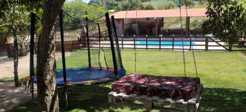 a swing in a yard next to a pool at Chácara Belas Artes in Sairé