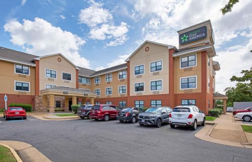 a hotel with cars parked in a parking lot at Extended Stay America Suites - Washington, DC - Alexandria - Landmark in Alexandria