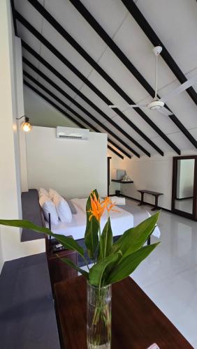 a vase of flowers on a table in a room at Nildiya Cottages in Elpitiya
