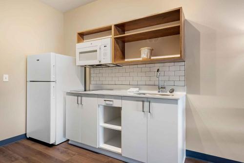 a kitchen with white cabinets and a white refrigerator at Extended Stay America Premier Suites - Austin - Kyle in Kyle
