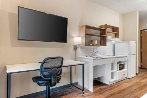 a room with a desk with a chair and a tv on the wall at Extended Stay America Premier Suites - Austin - Kyle in Kyle