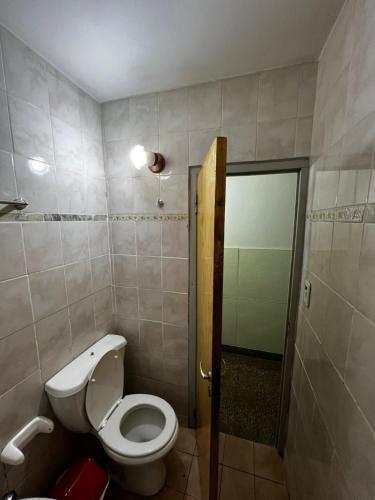 a small bathroom with a toilet and a shower at Hotel Residencial Independencia in San Rafael