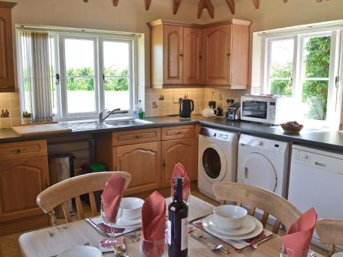 a kitchen with a table with chairs and a sink at Hawthorne Cottage - Py8 in Preston