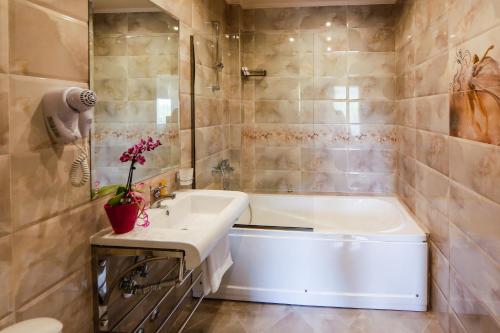 a bathroom with a white tub and a sink at Family Hotel Ognyanovo in Ognyanovo