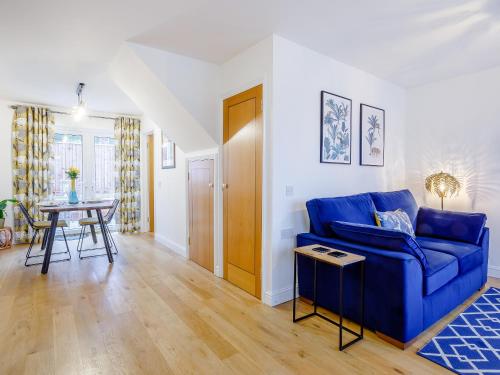 a living room with a blue couch and a table at Vineyard's Apartment in Ely