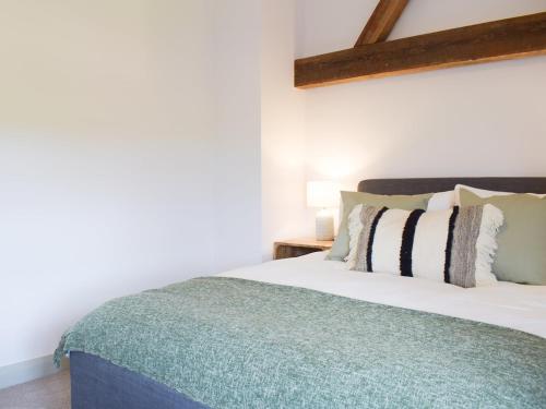a bedroom with a white bed with a green blanket at The Dairy - Uk34564 in Whitchurch