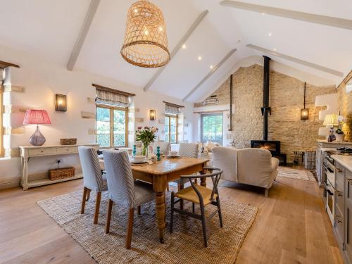 una cucina e un soggiorno con tavolo e sedie in legno di The Barn a Shipton under Wychwood