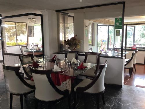a dining room with a table and chairs and mirrors at Hostería El Prado in Ibarra