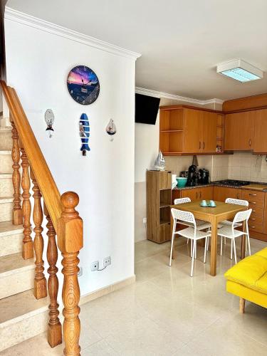 una cucina e una sala da pranzo con tavolo e sedie di Casinha do Carapau - Nazaré a Nazaré