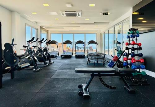 - une salle de sport avec tapis de course et vélos d'exercice dans l'établissement Apartamento Pé na Areia com Piscina e Vista Mar ao lado do Itaparica Food Park, à Vila Velha