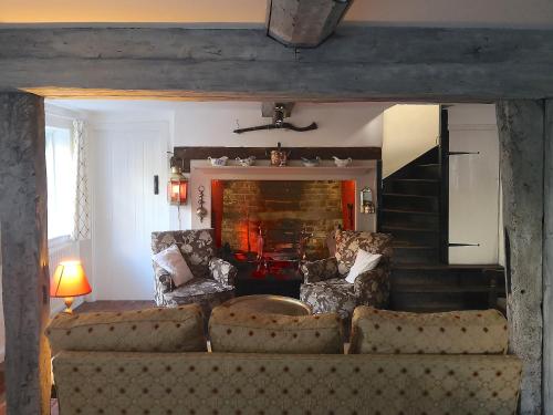a living room with a couch and two chairs at Apple Tree Cottage in West Wittering