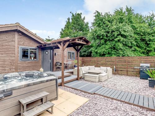 a backyard with a hot tub and a fence at Orchard Retreat in Kirton