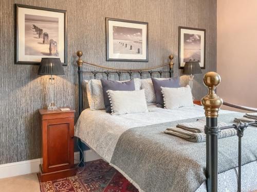 una camera con letto e tavolo con lampade di Hero Cottage a Holt