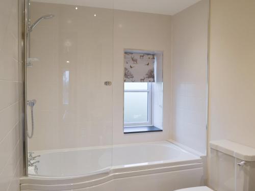 a white bathroom with a shower and a toilet at Cowslip - Uk13138 in Barnby Moor
