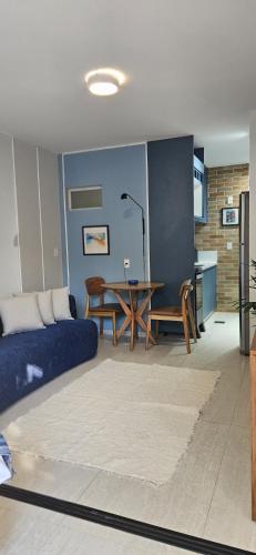 a living room with a blue couch and a table at Um lugar de charme e aconchego - Rosa! in Brasília
