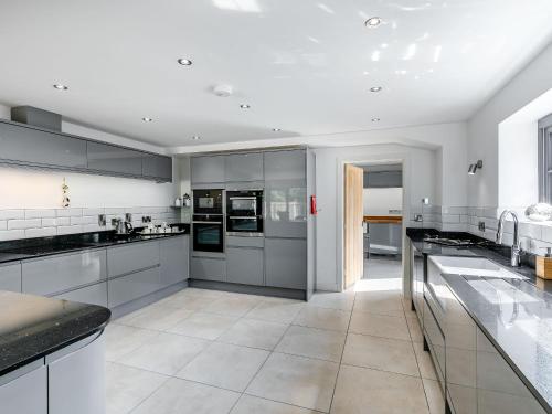 a large kitchen with white counters and appliances at Howell Hall Barn in Howell