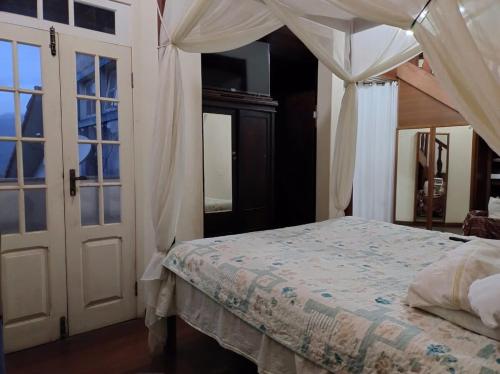 a bedroom with a bed with a canopy at Surpreendente in Ouro Preto