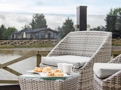 a wicker chair with two plates of donuts and drinks at River Tees Lodge - Ukc4064 in Nunthorpe