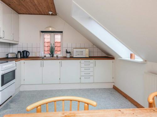 a kitchen with white cabinets and a table at 4 person holiday park home in Give in Give