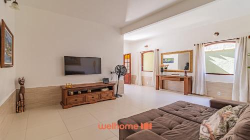 a living room with a couch and a flat screen tv at Casa em Paraty com piscina e churrasqueira in Paraty