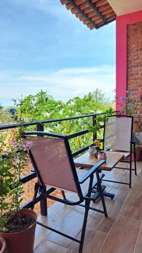 two chairs sitting on a balcony with a view at Casa Axixic in Ajijic