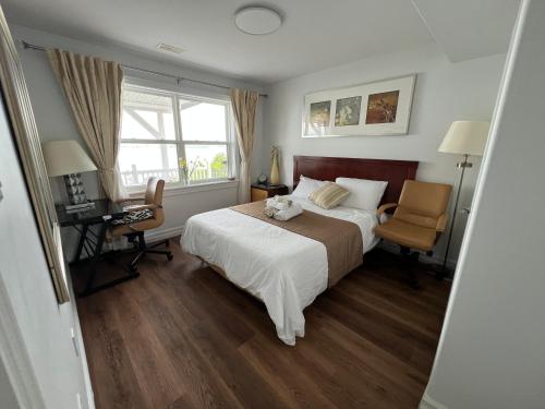 a bedroom with a bed and a desk and a window at Entire Cozy Apartment with Share Jacuzzi to Enjoy Amazing Views in Halifax