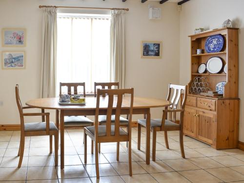 a dining room with a wooden table and chairs at 2 Sawmill Cottages in Puncknowle