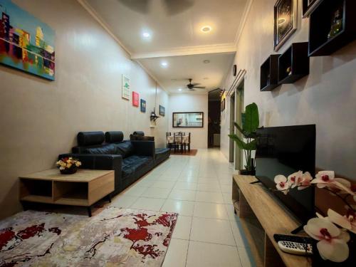 a living room with a black couch and a fireplace at Homestay Sakinah No 39 in Tanjung Malim