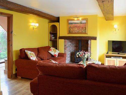 a living room with two brown couches and a fireplace at The Landings Cottage in Nun Monkton