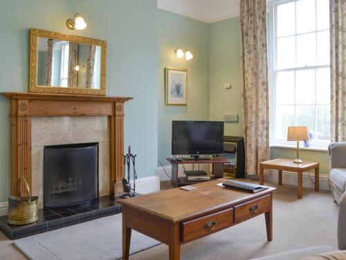 a living room with a fireplace and a television at Apartment 3-Uk33247 in Grayrigg