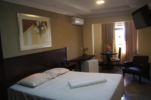 Candango Aero Hotel في برازيليا: غرفه فندقيه بسرير وكرسي
