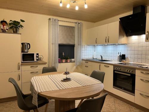 una cucina con tavolo e sedie in una cucina di Im Hof a Pittenbach