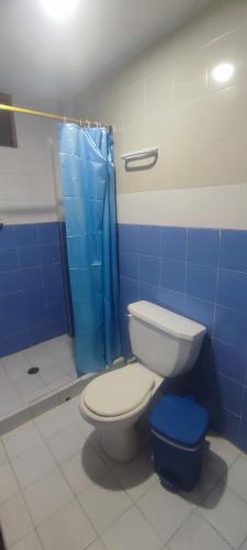 a bathroom with a toilet and a blue shower at Hotel los Lanceros 