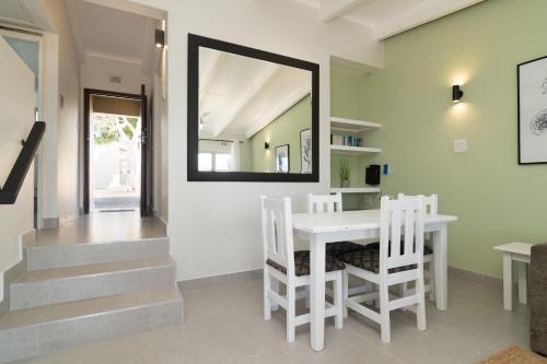 a dining room with a table and chairs and a mirror at Ballito Bliss Chalet at Chaka's Rock Chalets 9 in Ballito